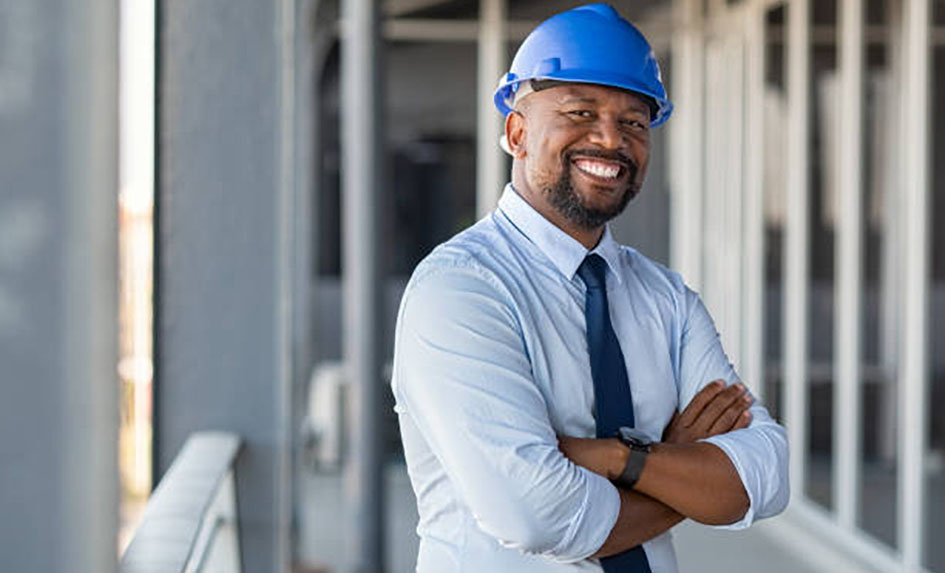An engineer with hands folded and smiling