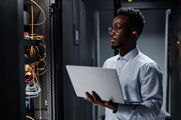 An IT professional holding a laptop